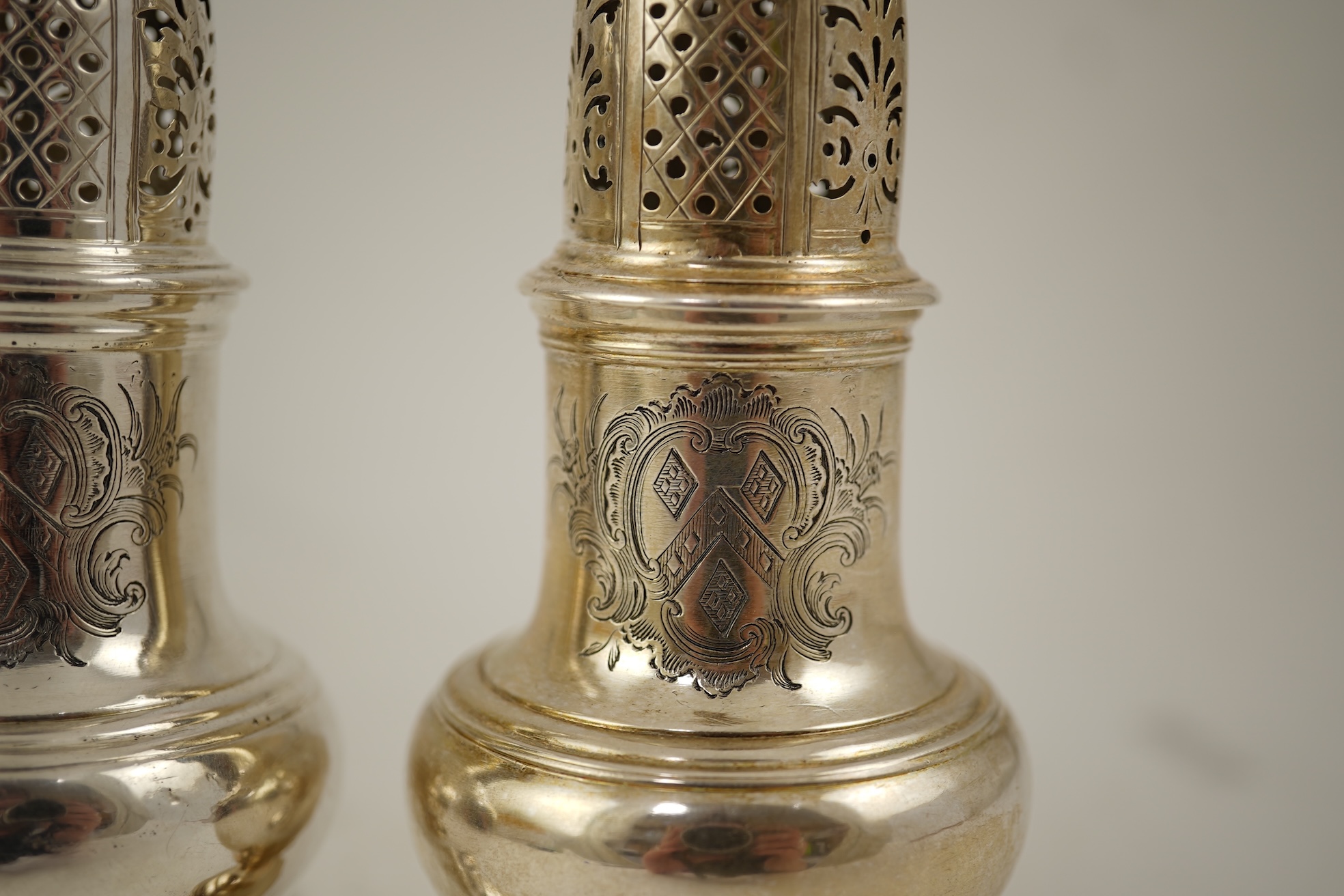A pair of George II silver baluster sugar casters, by Samuel Wood
